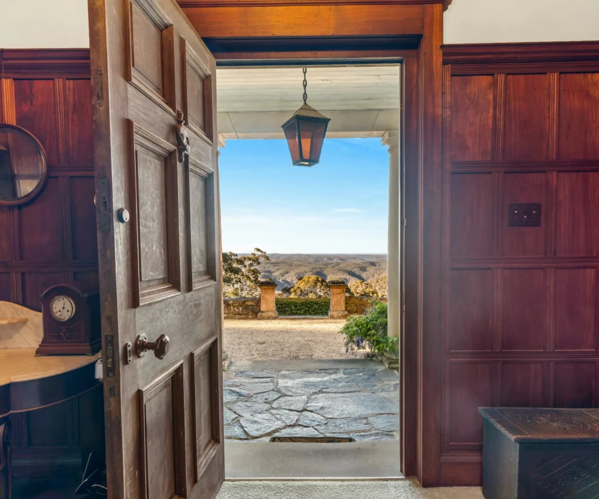 A timber panelled entryway with an open door looking out to the Blue Mountains