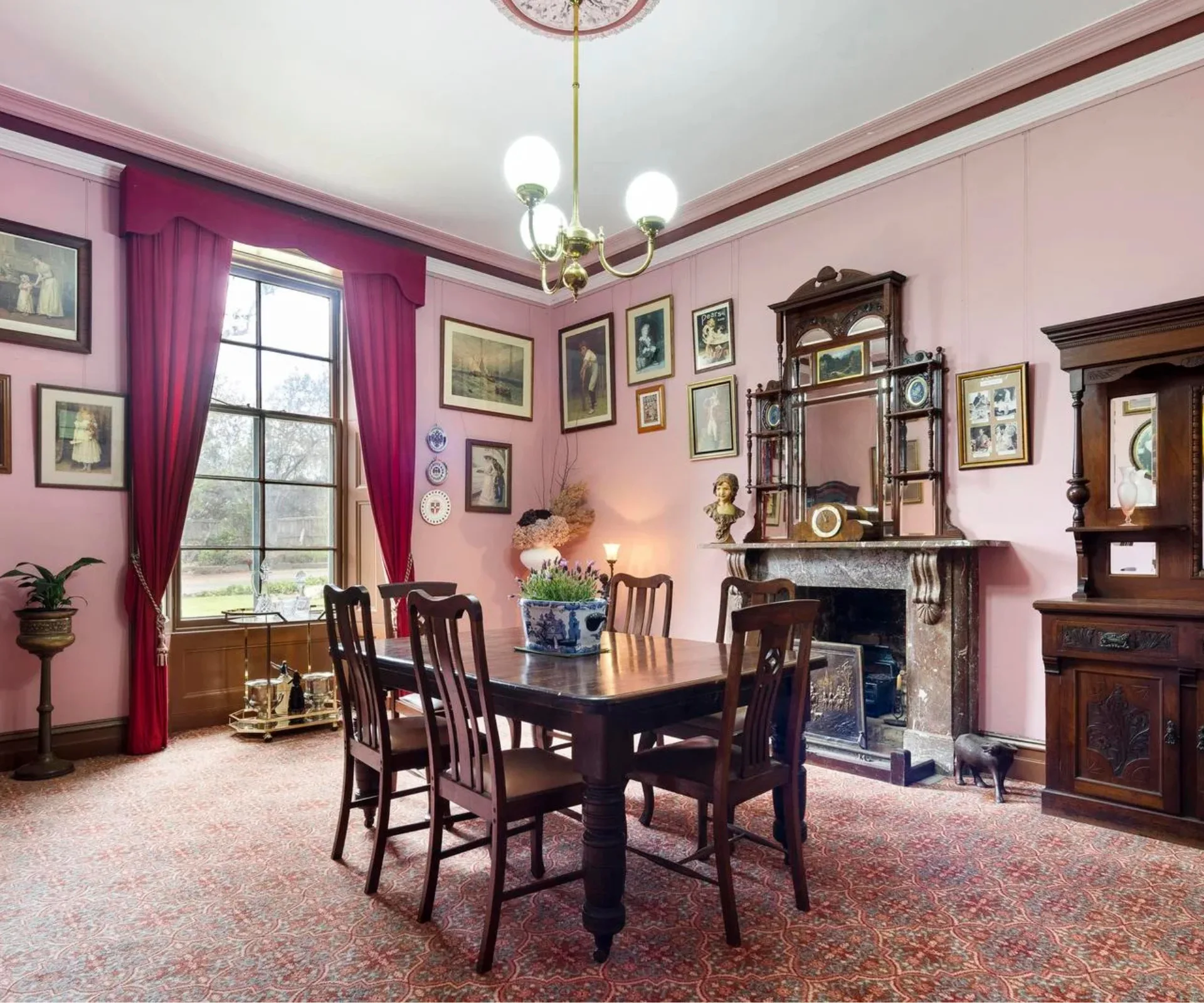 A pink dining room with a stone fireplace in Overnewton Castle