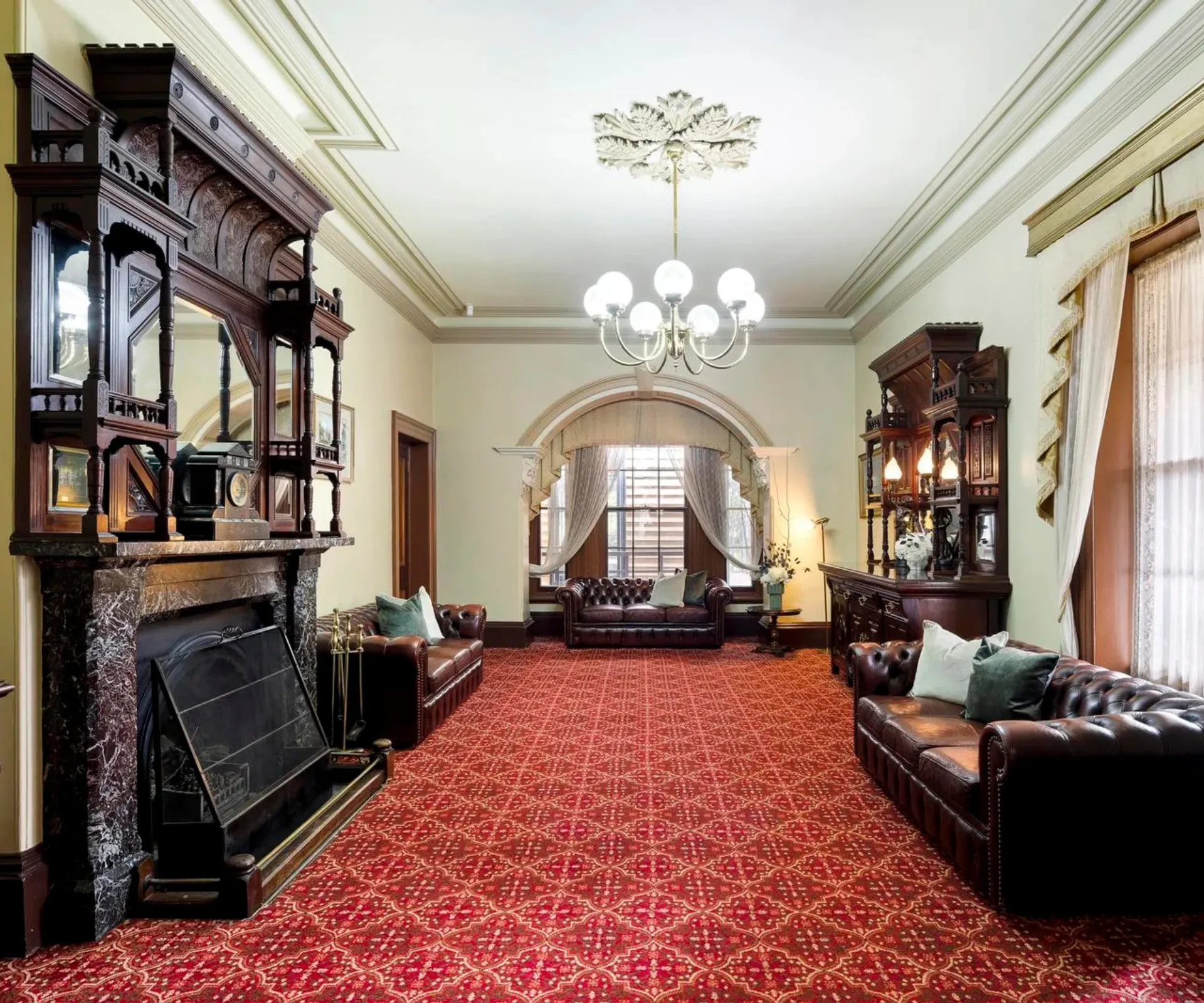A formal sitting room with an ornate marble fireplace