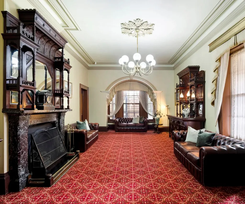 A formal sitting room with an ornate marble fireplace