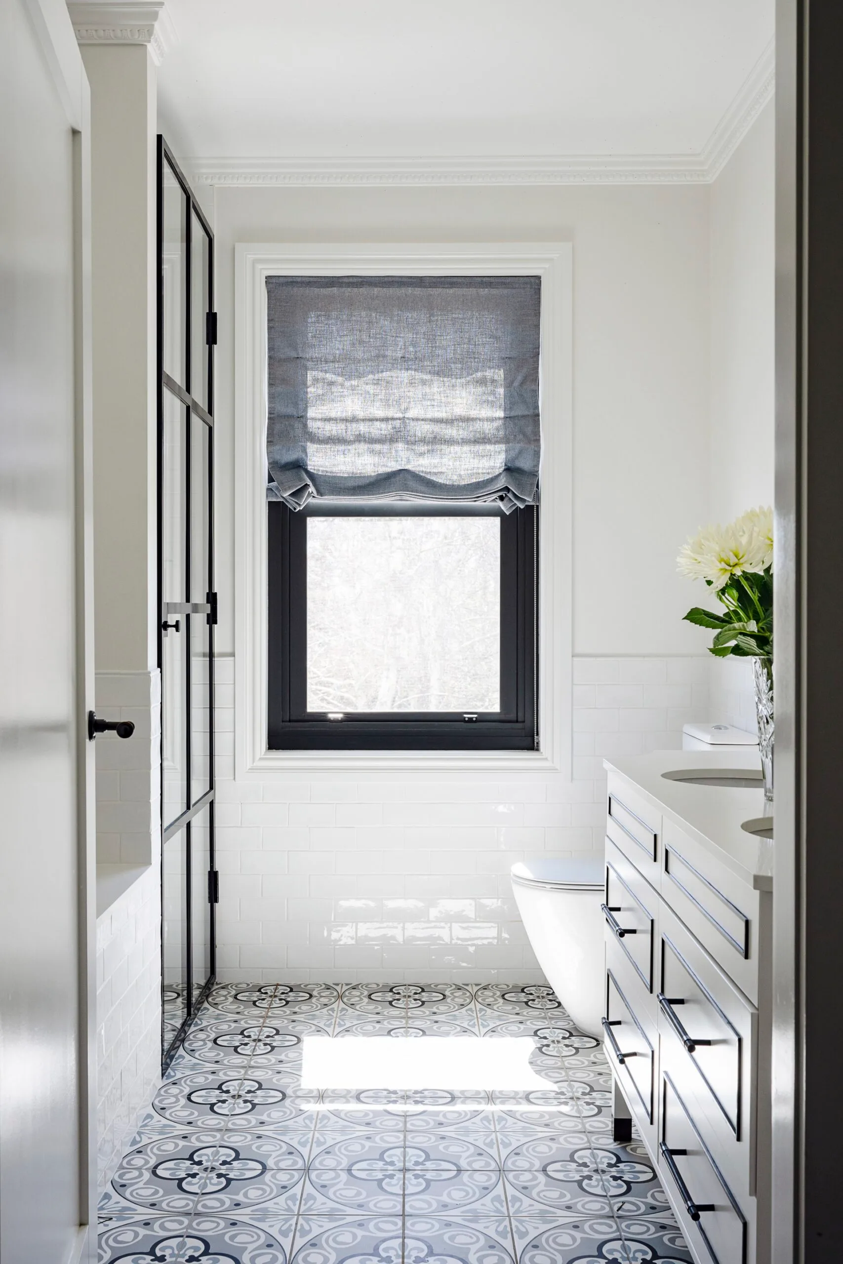 A white bathroom with patterned tiles