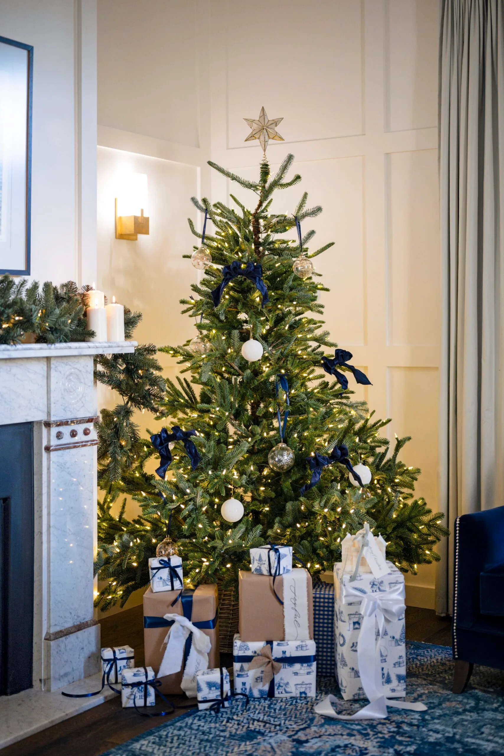 A Christmas tree with blue ribbons and white baubles