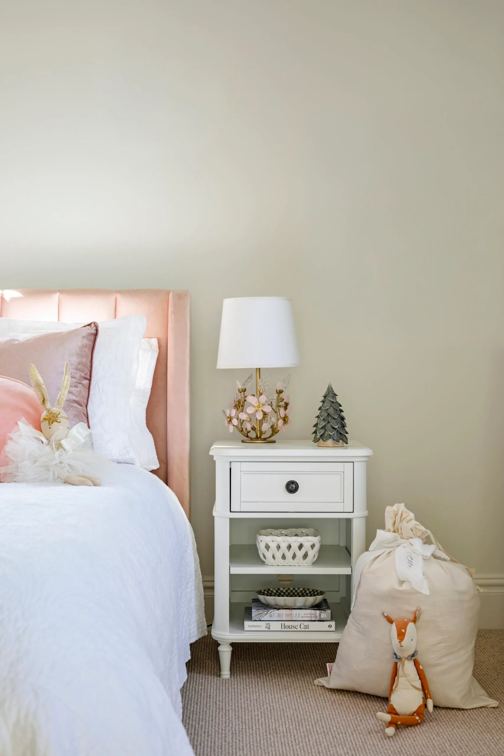 A neutral bedroom with a peach-toned headboard and Christmas decorations