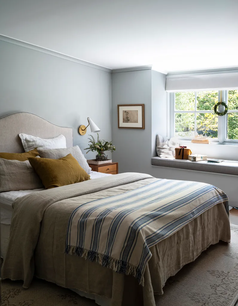 A master bedroom decorated in blue and mustard tones