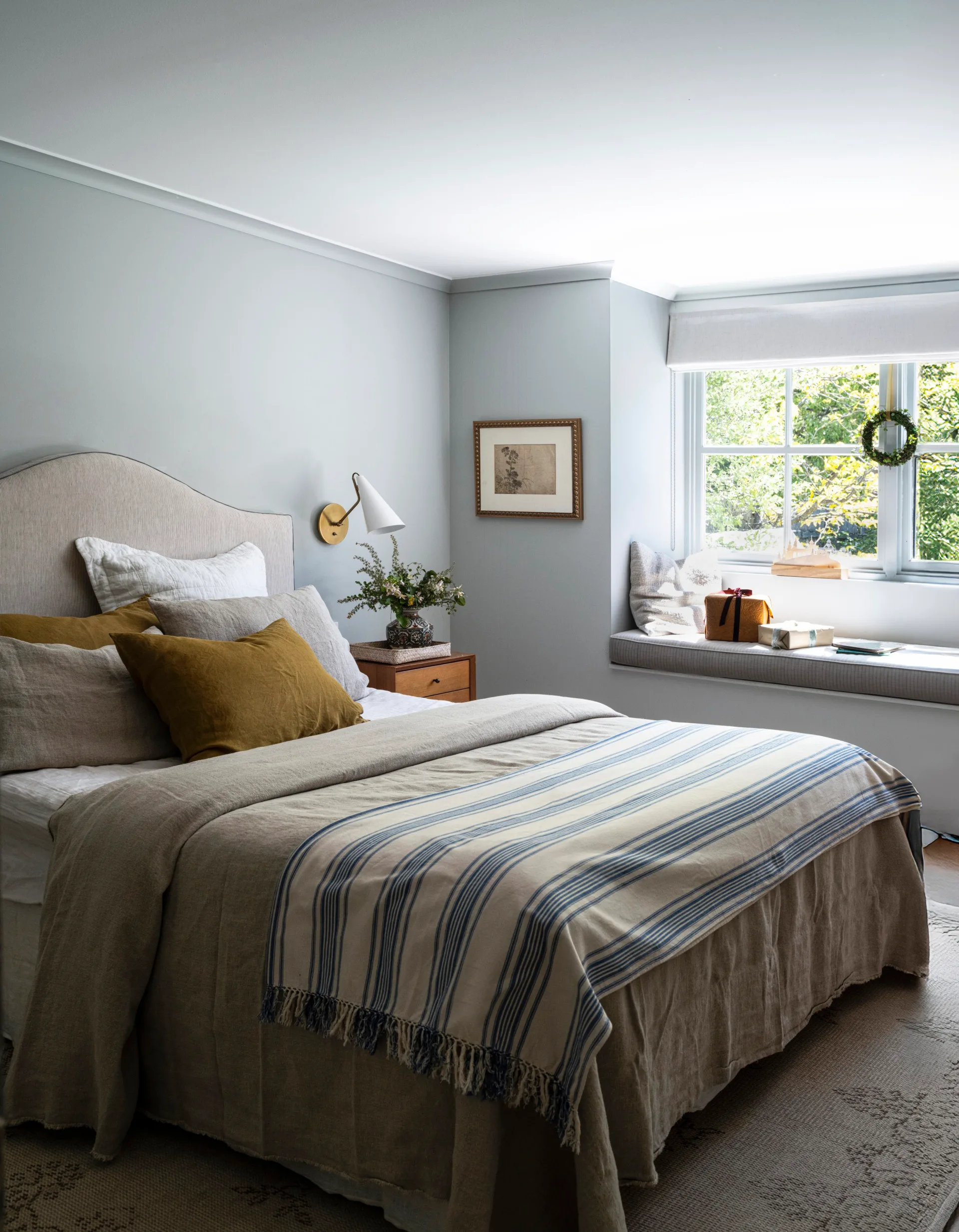 A master bedroom decorated in blue and mustard tones