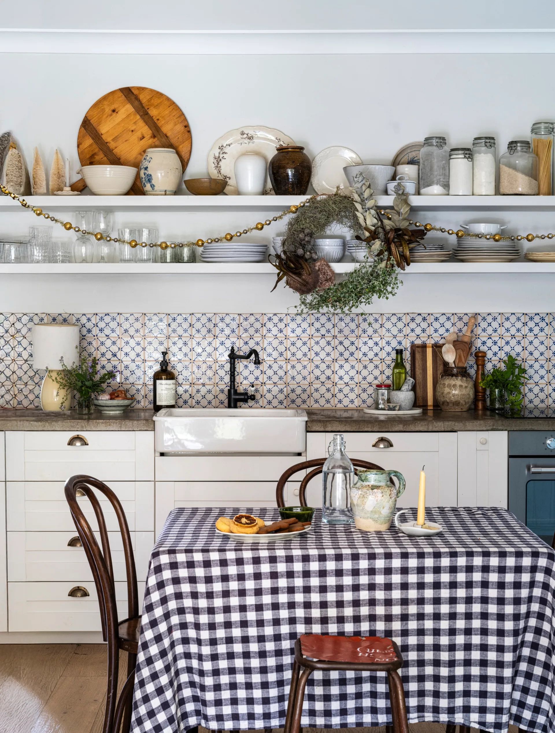 A country kitchen featuring a gingham tablecloth and blue and white tiles