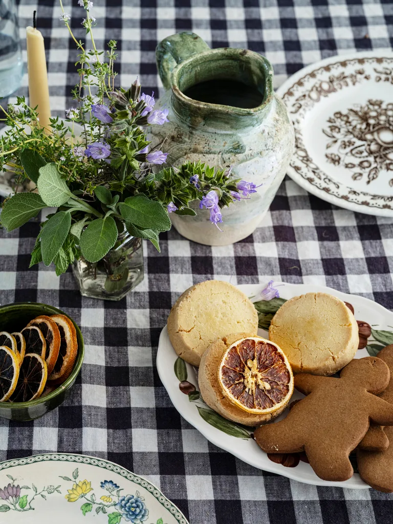 Cookies, dried orange slices and a black and white tablecloth.