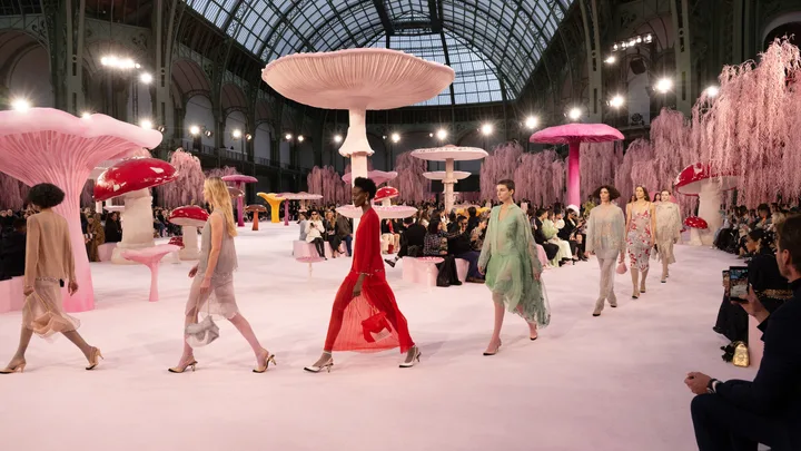 Models walking down a pink runway surrounded by giant pink mushrooms at the HANEL Spring Summer 2026 Haute Couture show