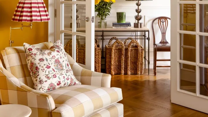 Yellow room interiors with plaid armchair and red and white stripe wall lamp