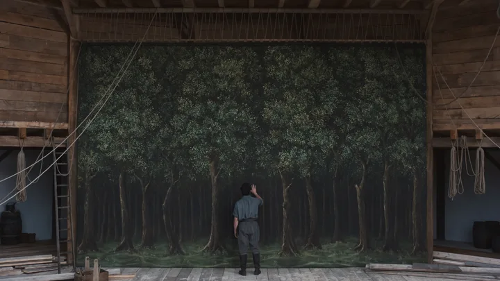 A still image of actor Paul Mescal standing in front of a landscape painting hung up on the stage of The Globe theatre, created for the Golden Globe winning film Hamnet.