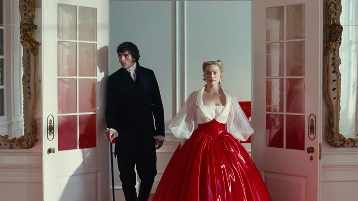 A film still from Wuthering Heights set design showing a man and woman entering a room through a set of white doors