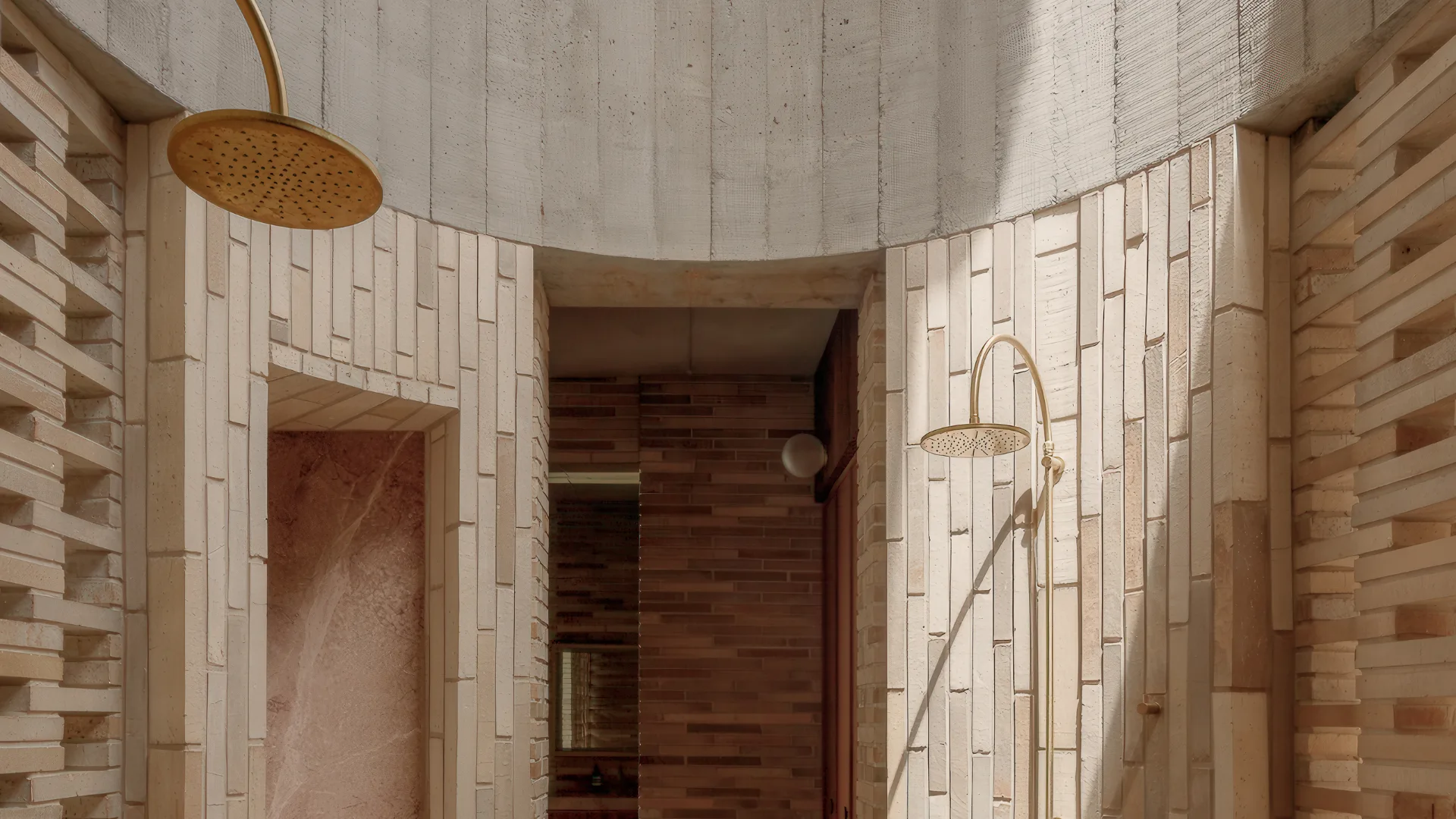 A curved shower made from sandstone with views of basin