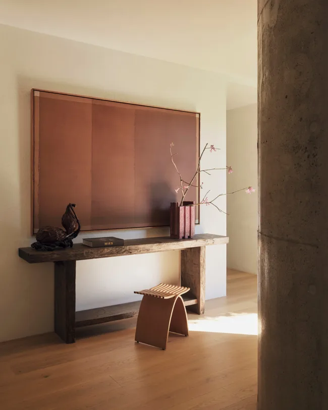 A contemporary artwork, timber sideboard, vase with flowers