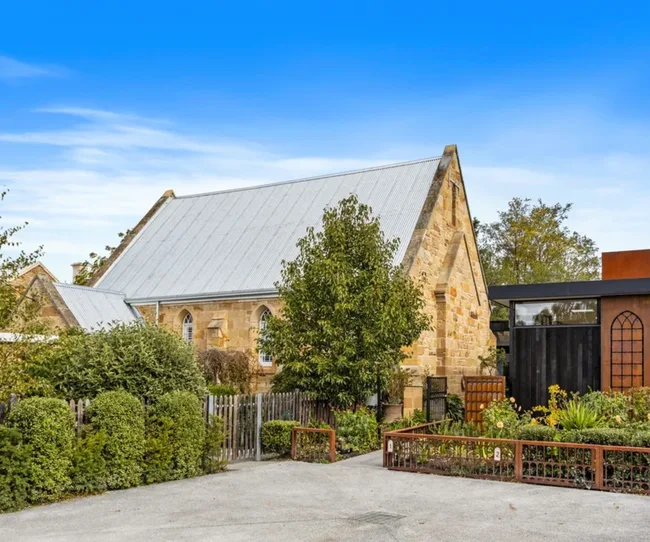 The stone facade of a church conversion surrounded by gardens in Richmond