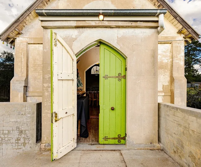 A country church for sale in Orange with a bright green church door.