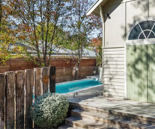 Church for sale Harcourt Victoria exterior with weathered timber floors, a mint green door and plunge pool pictured around the side of the dwelling.