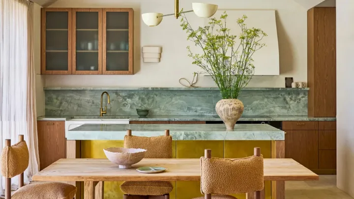 A kitchen with green benchtops and timber joinery
