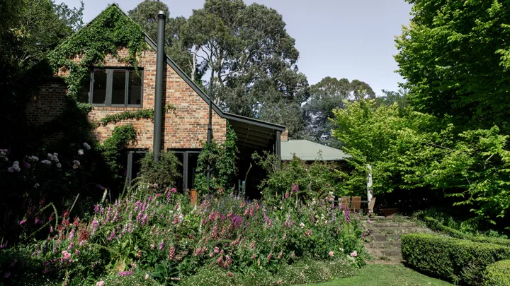 A flourishing garden outside country red brick home