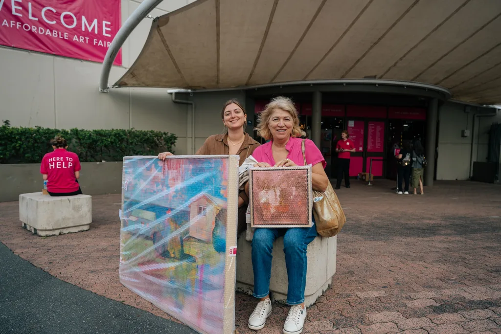 Happy visitors with artworks purchased from the Affordable Art Fair