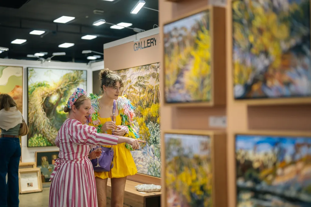 Art-lovers looking a fellow floral paintings at the Affordable Art Fair