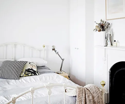 Bedroom with metal frame bed and white sheets