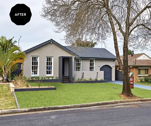 "Renovated single-story house with grey facade, well-maintained lawn, and minimalistic landscaping under a tree."