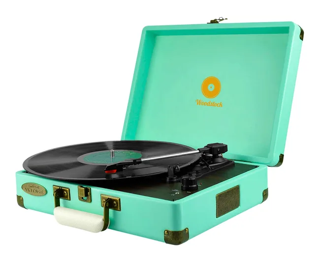 Turquoise vintage turntable with a record playing, labeled "Woodstock," in an open suitcase-style design.