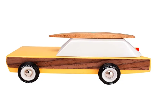 Toy car with a yellow body, white top, wood accent, and a surfboard on the roof.