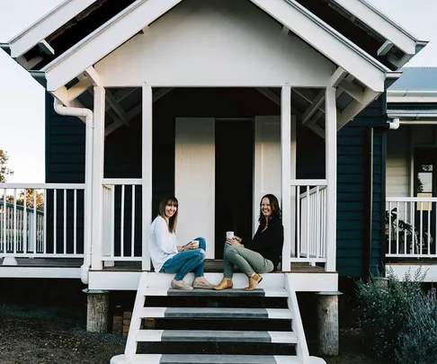 Mother and daughter on the front step of a black and white converted courthouse