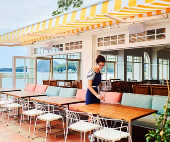 Outdoor courtyard at Shoal Bay Country Club where a waitress serves drinks