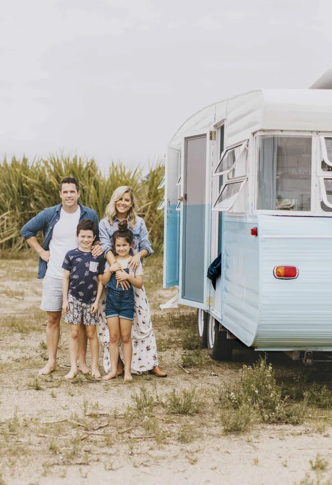 michael and carlene with their kids in front of their vintage caravan