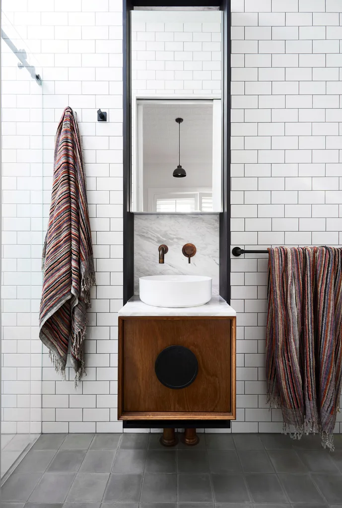 A bathroom with subway tiles and timber vanity