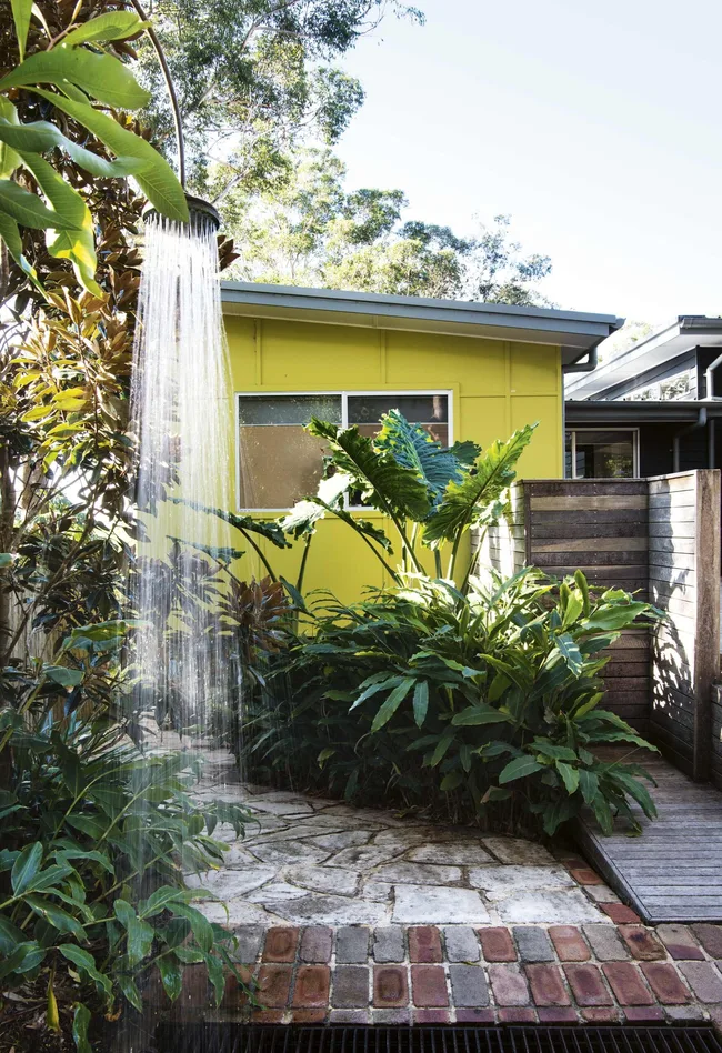 A coastal garden with an outdoor shower and tropical plantings