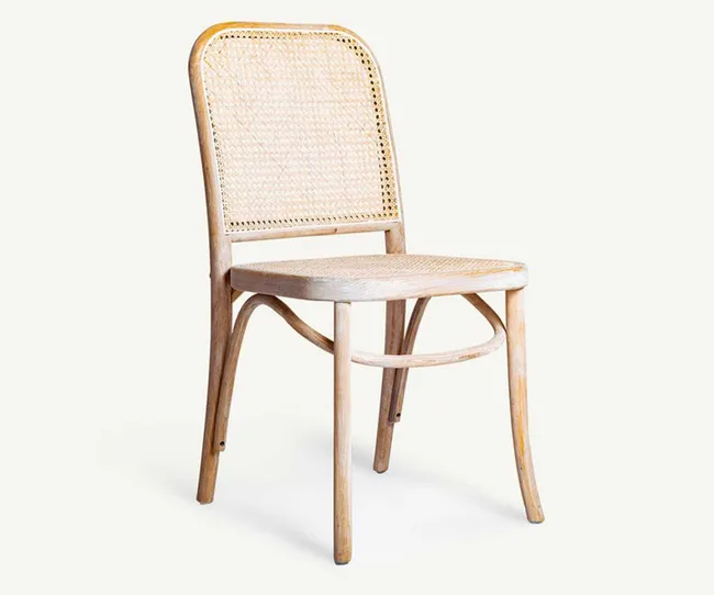 Wooden chair with woven cane back and seat on a light background.