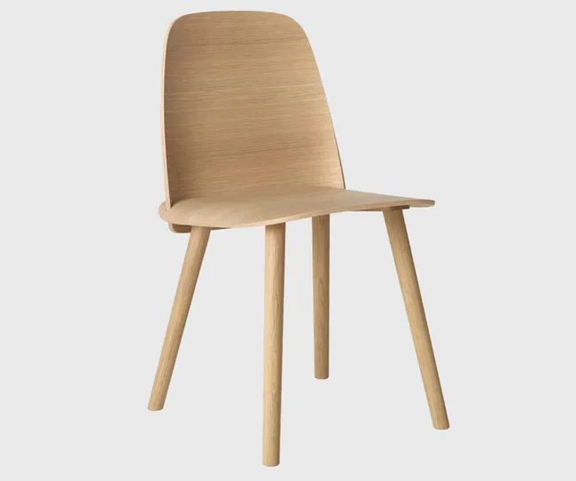 A simple, modern wooden chair with a curved back and four legs, set against a plain background.