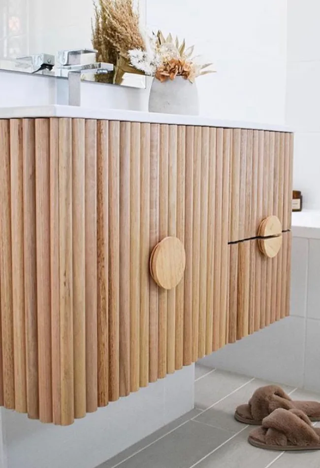 Kmart storage lids became handles in this clever bathroom cabinet design.