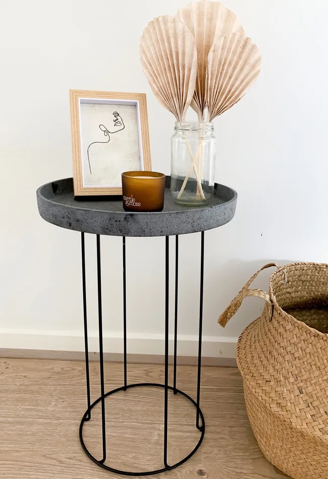 A Kmart plant stand turned into a side table with the addition of a tray on top.
