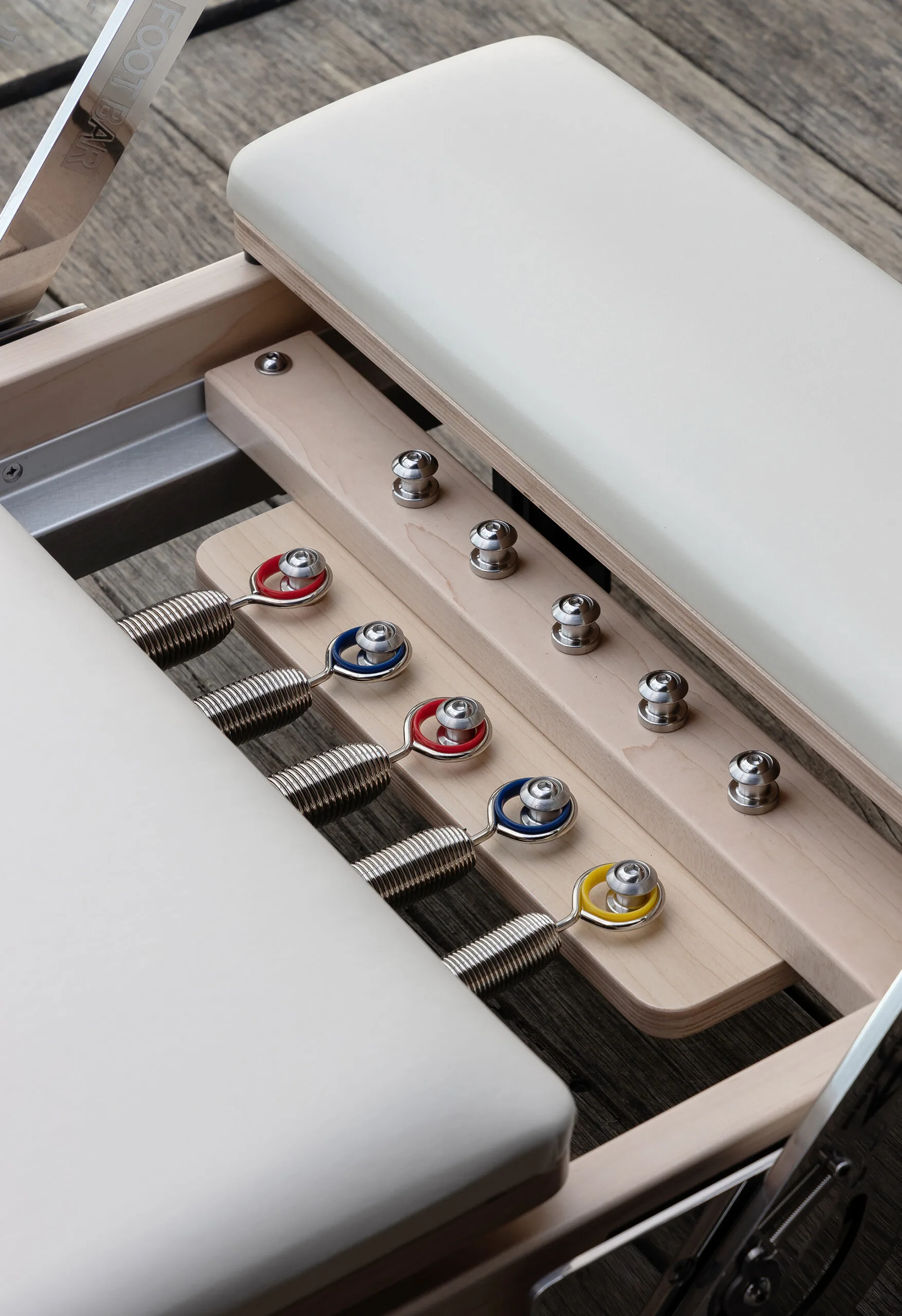 Detail shot of the spring attachment on a Pilates reformer machine. 