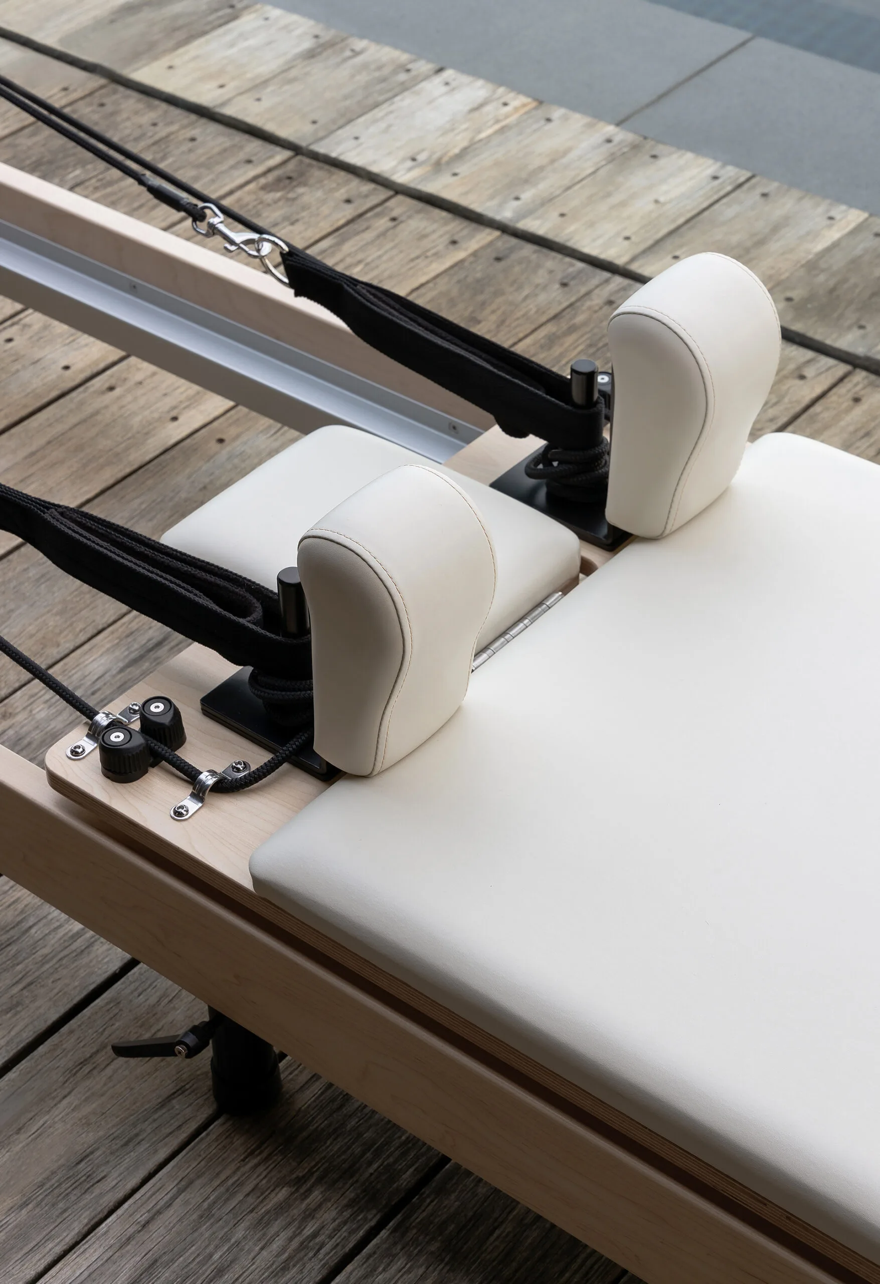 Close up of a pilates reformer machine with ivory base. 