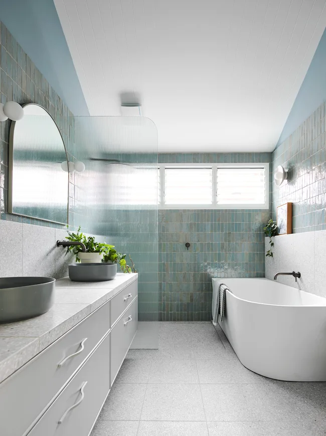 blue tiled bathroom with back to wall bath