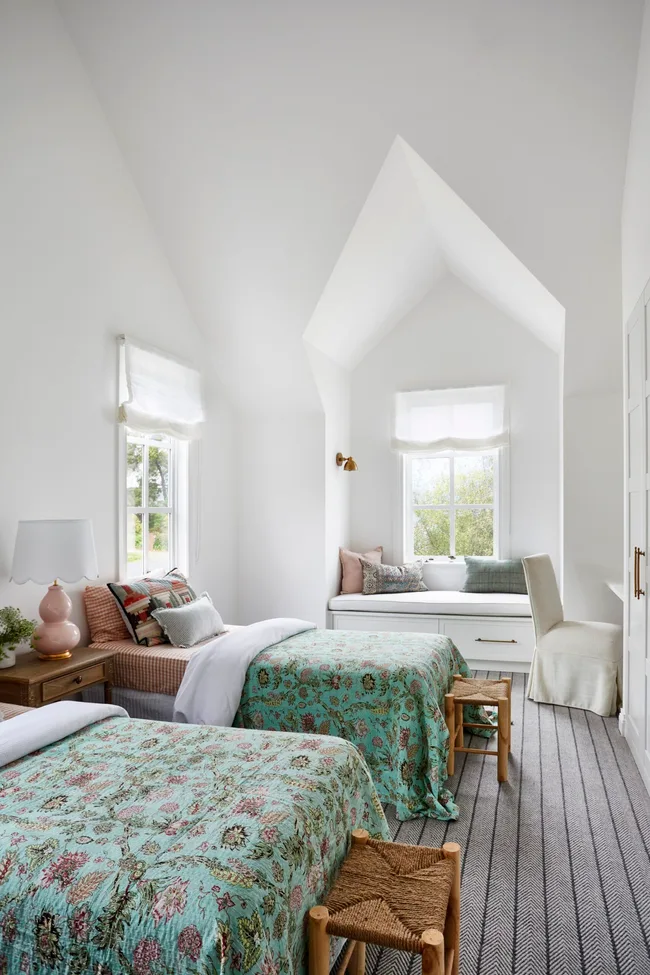 A kids bedroom with playful bedding and a window seat
