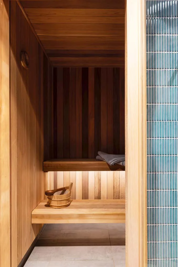 A timber sauna with green tiles on the outside