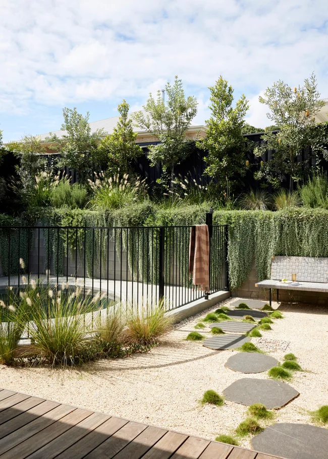 A tranquil garden with elements of Japanese design including natural stone and traditionally-preserved timber, as well as a pool.