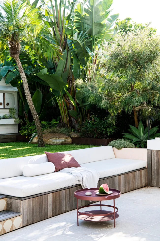 A tropical garden with a built-in outdoor sofa