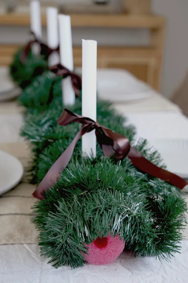 pool noodle table runner with green tinsel and pillar candles